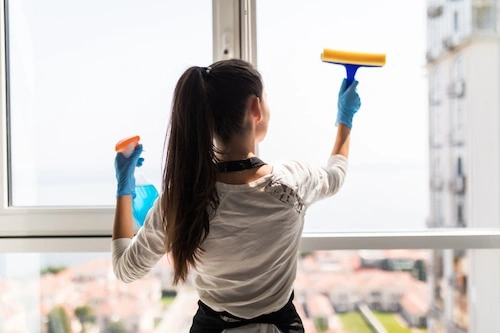 Easy Life Solution technician cleaning a residential window screen with spray and cloth for a streak-free finish